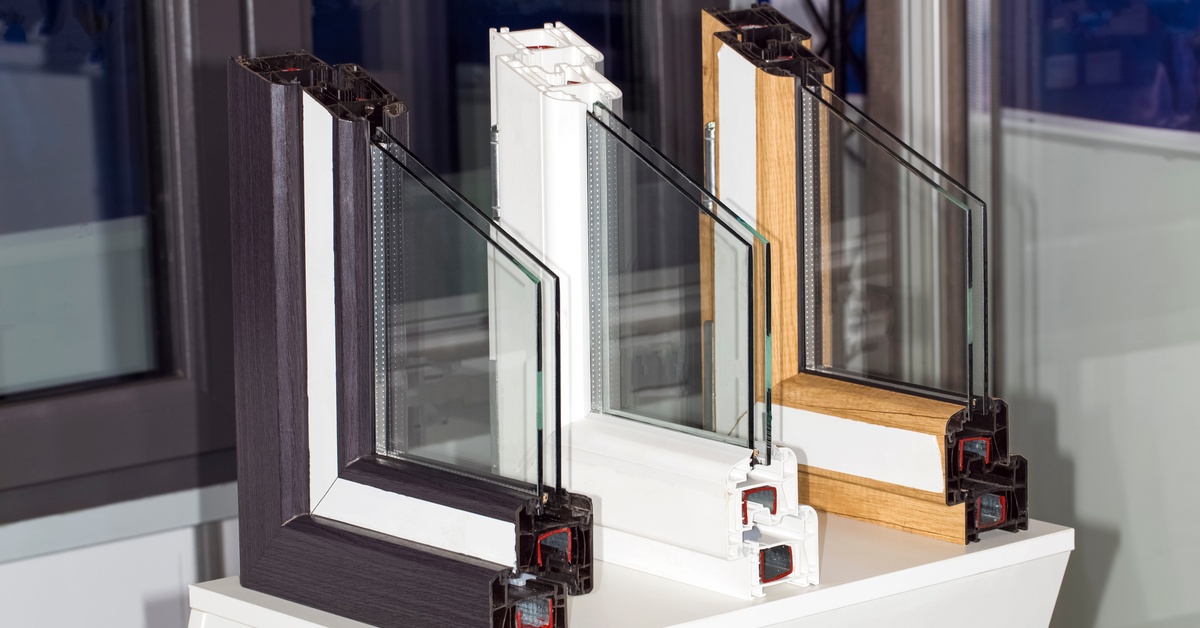 Three different profile sections of a multicompartment double-glazed window sit together on a white surface.