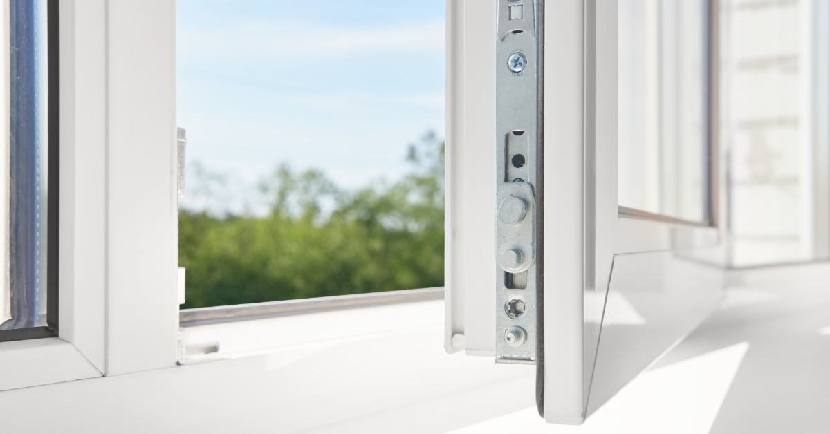 A close-up shows an open white vinyl window frame with visible locking hardware and a blurred view of greenery outside.